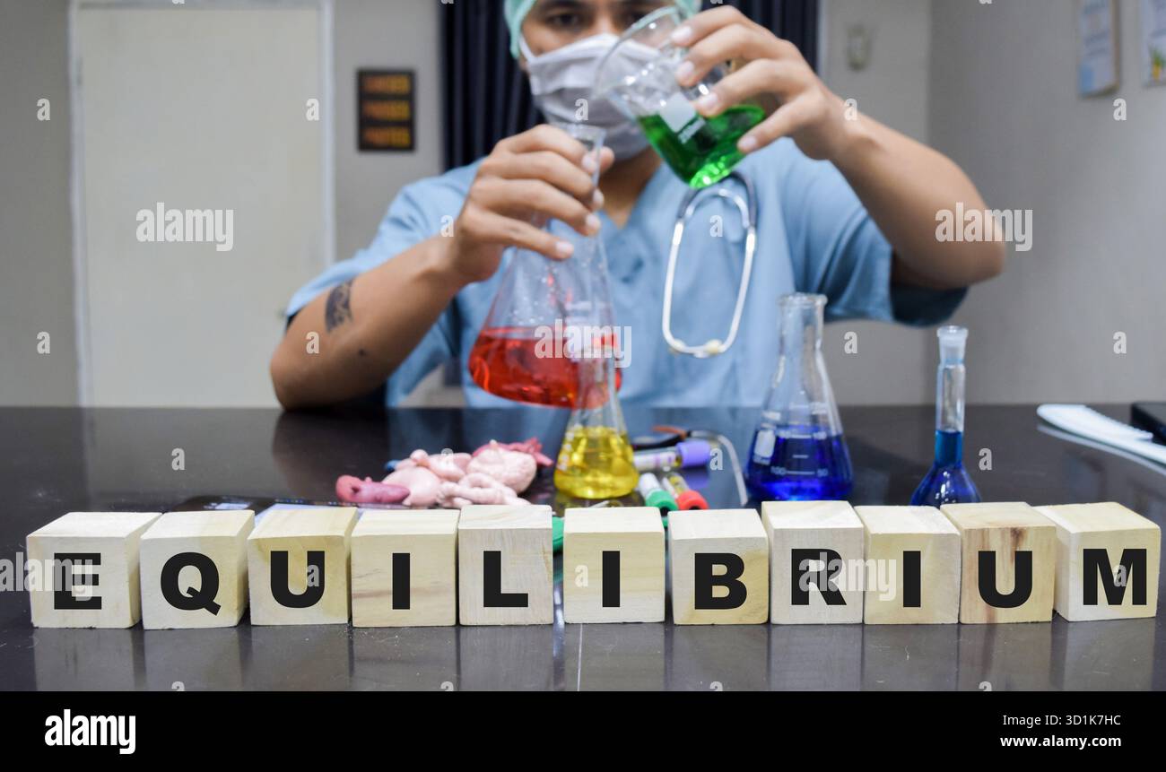 Un tecnico di laboratorio che esplora esperimenti chimici relativi all'equilibrio. concetto di ricerca scientifica Foto Stock