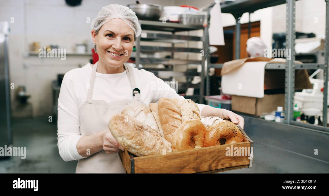 Donna, panificio e felice con un cesto di pane in ritratto, orgoglio e imprenditore con prodotti in negozio. Persona matura, sorriso e proprietario di una piccola impresa Foto Stock