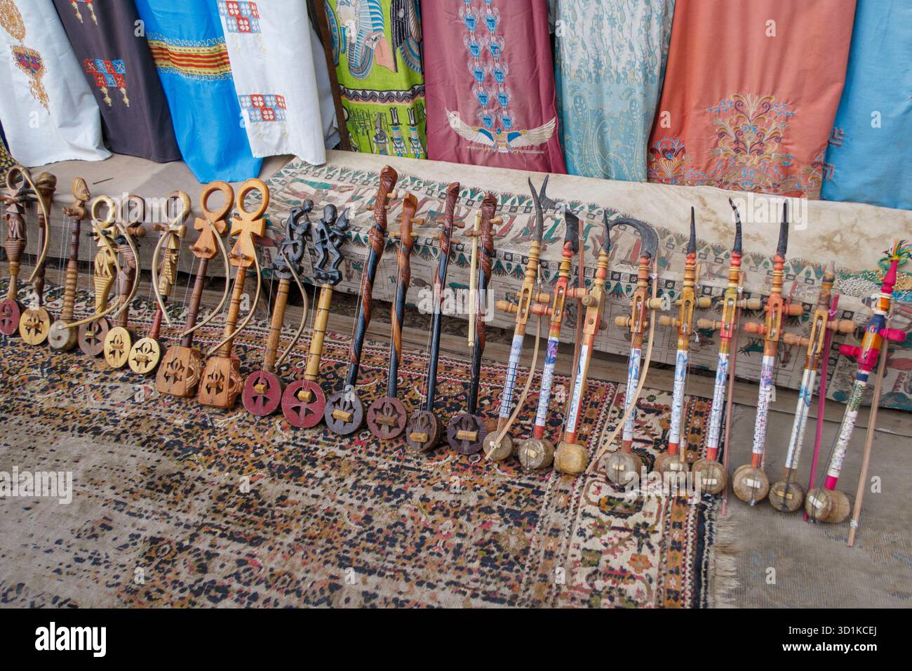 Rababa egiziana tradizionale - strumenti musicali in legno esposti in vendita su un tappeto a motivi geometrici in un ambiente di mercato Foto Stock