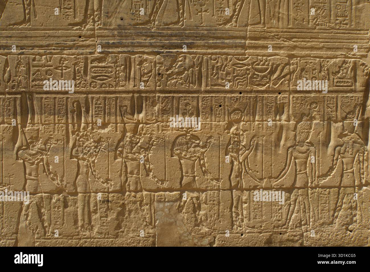 Antiche pareti in pietra egiziane che mostrano geroglifici e figure in pose cerimoniali e religiose presso il Tempio di Edfu Foto Stock
