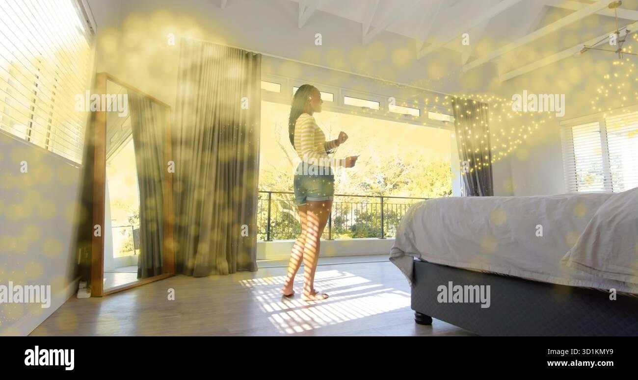 Donna a piedi nudi che tiene una tazza di caffè all'interno della camera da letto a volta, con specchio e ringhiera del balcone Foto Stock