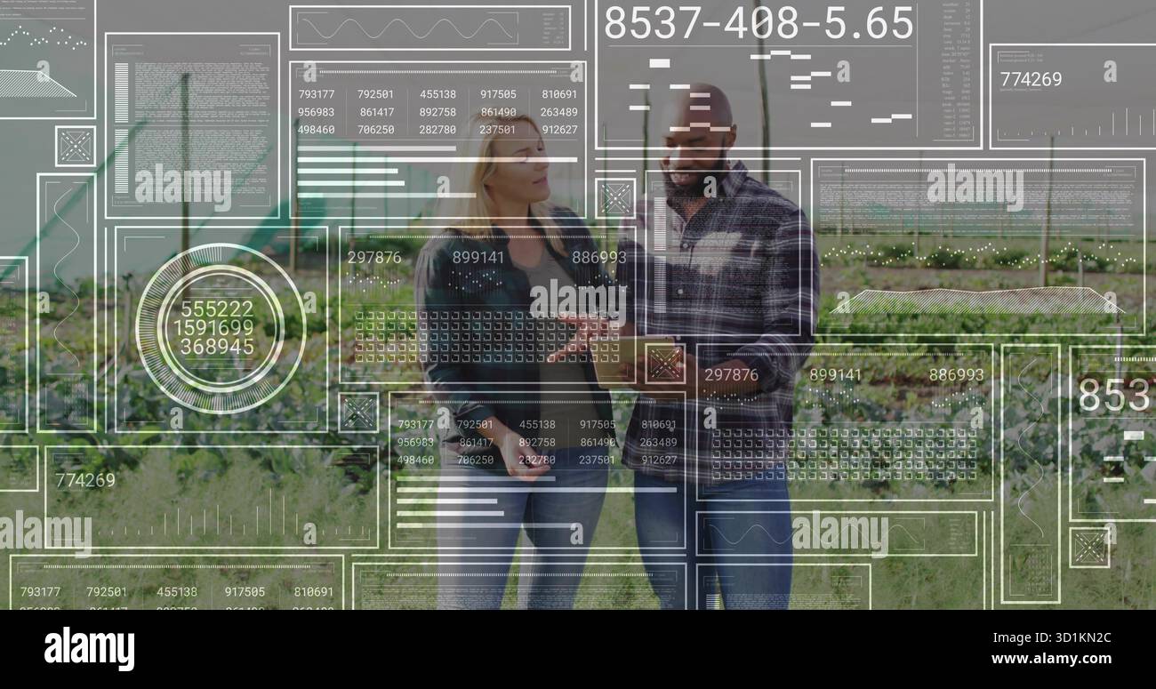 Due colleghi che si occupano di camicia flanella e giacca in denim consultano tablet nel campo del raccolto, con sovrapposizioni AR Foto Stock