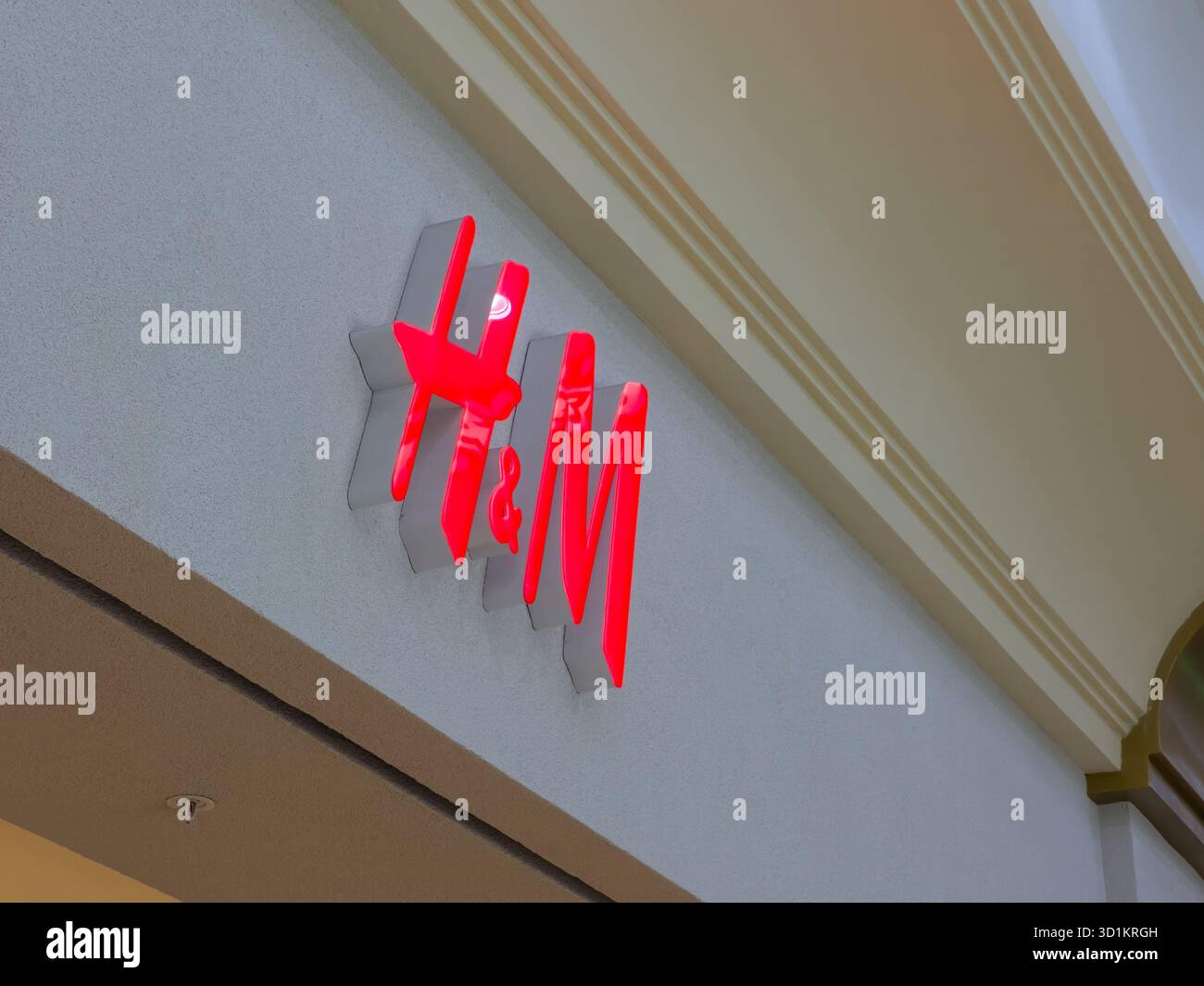 20 settembre 2025, Aktobe, Kazakistan: Primo piano di un logo H e M illuminato rosso su un muro. Foto Stock
