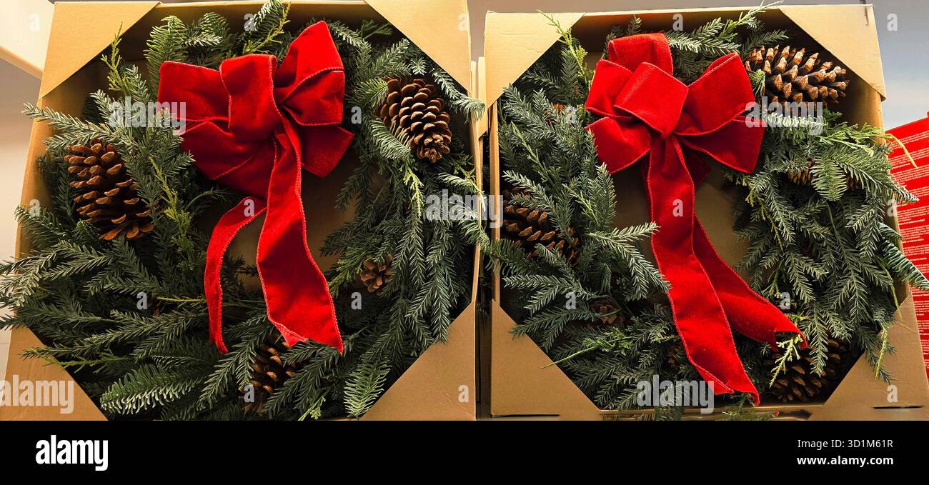 La corona delle feste presenta un fiocco rosso vivace e pineconi, splendidamente disposti in confezioni decorative, perfette per le feste. - Immagine stock catturata con smartphone