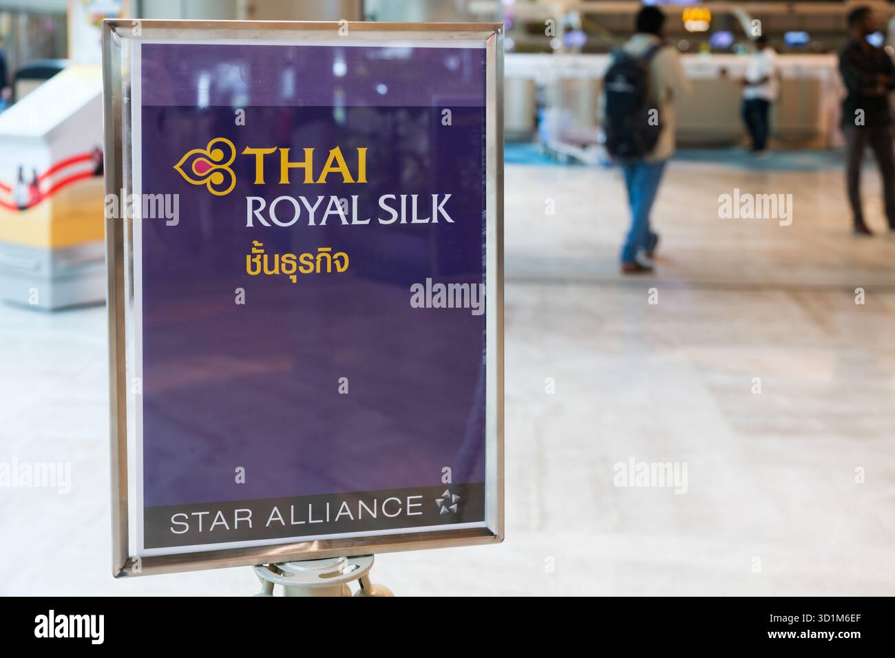Il cartello lounge Thai Royal Silk si trova in un moderno terminal presso l'Aeroporto di Changi. I viaggiatori impegnati si vedono passare davanti, mostrando la vivace vita aeroportuale. Foto Stock
