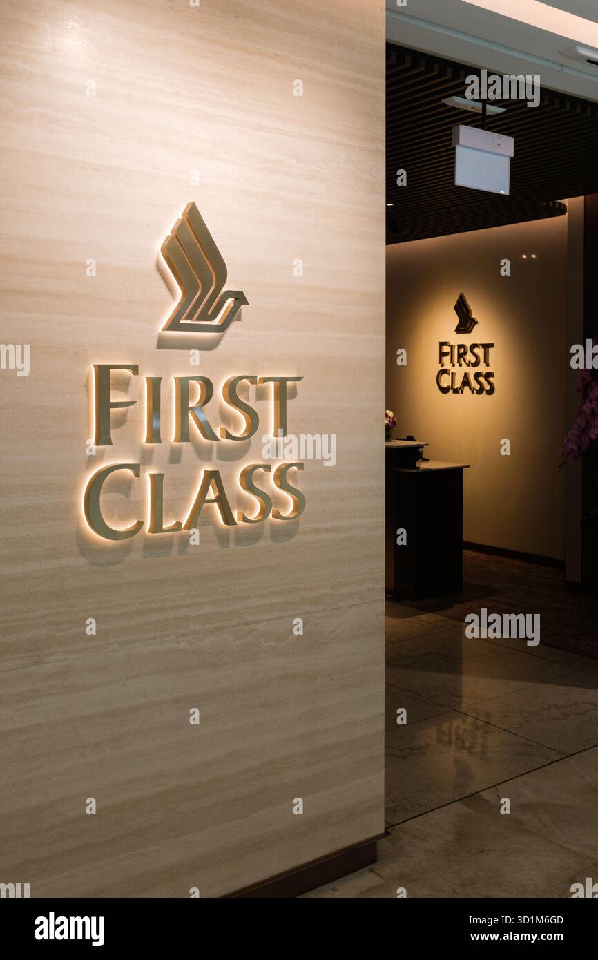 L'ingresso lounge di prima classe vanta un design elegante con una calda illuminazione, accenti dorati e un decor elegante, accogliendo i viaggiatori con stile Foto Stock