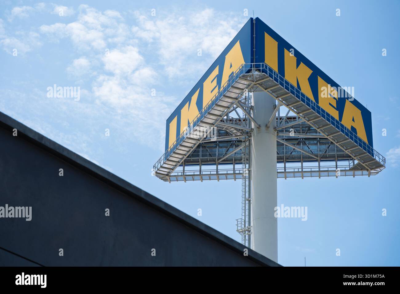 Un cartello IKEA Store presenta una scritta gialla su sfondo blu, posizionata in alto sopra il punto vendita, con un cielo azzurro sullo sfondo. Foto Stock