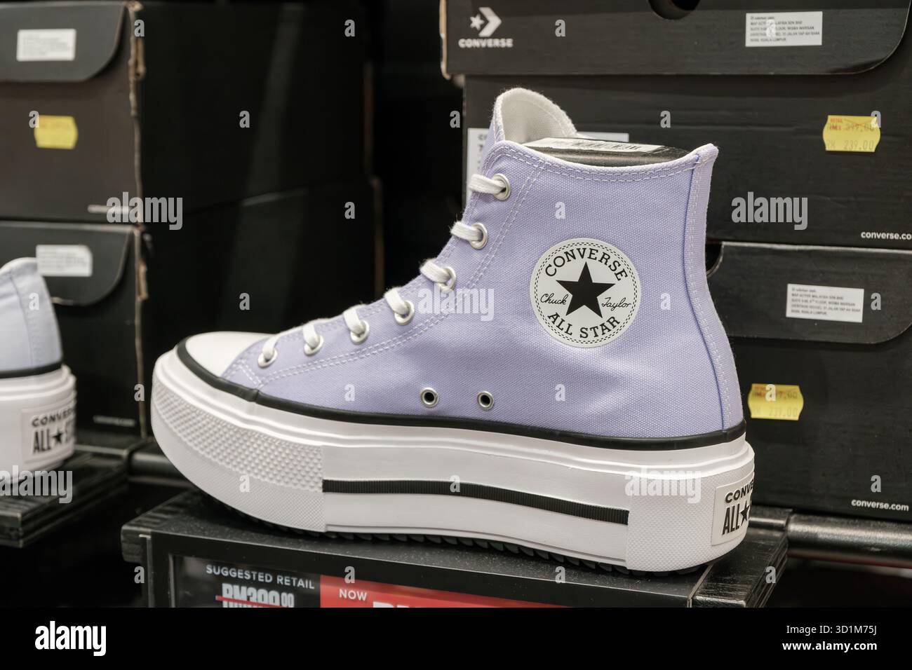 Le sneaker alte Converse All Star in tela viola chiaro presentano un logo rotondo e una suola bianca, presentate su uno scaffale in un punto vendita con labbro trasparente Foto Stock