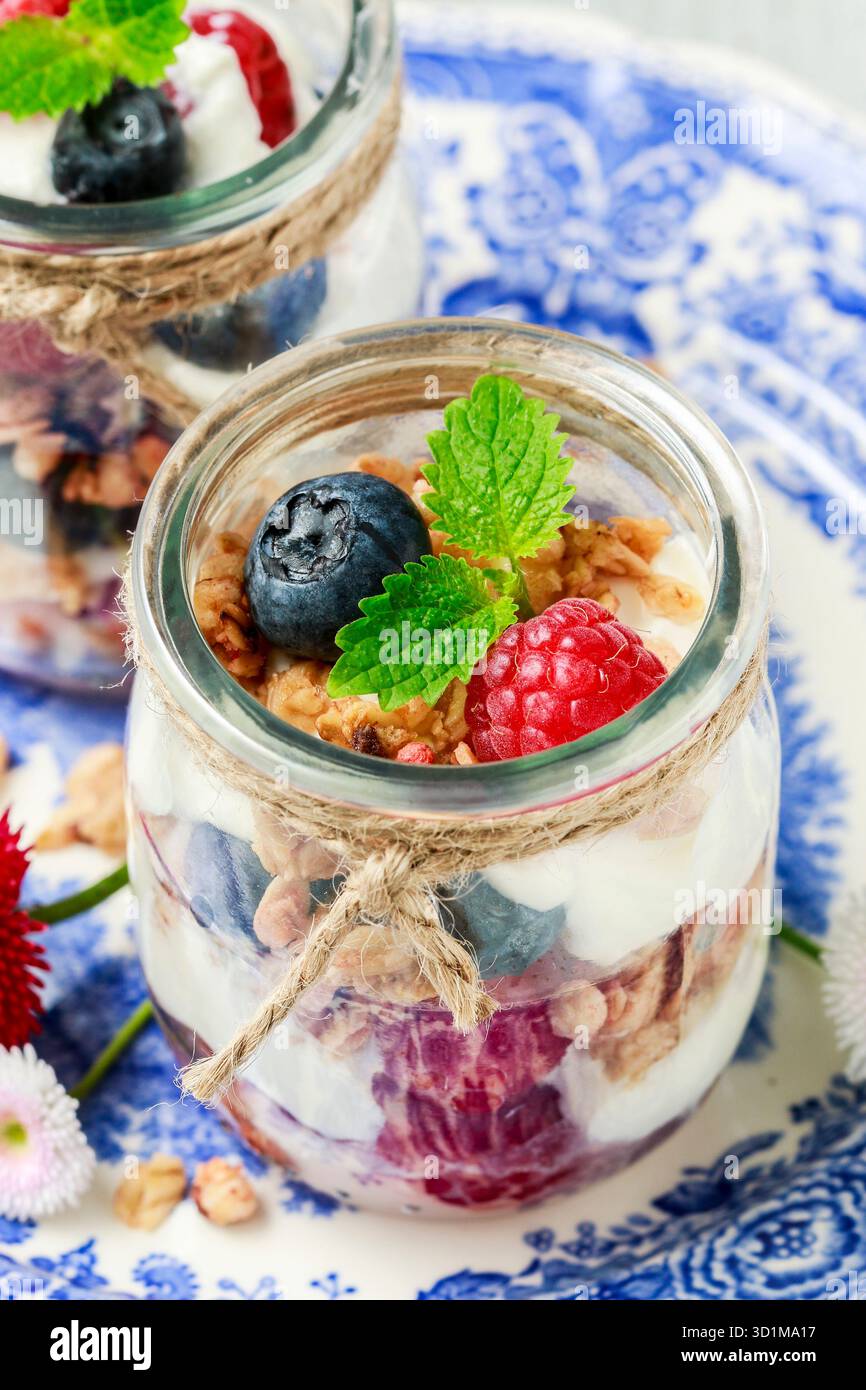 Vasetti in vetro con frutta e panna montata. Gustoso dessert estivo. Foto Stock