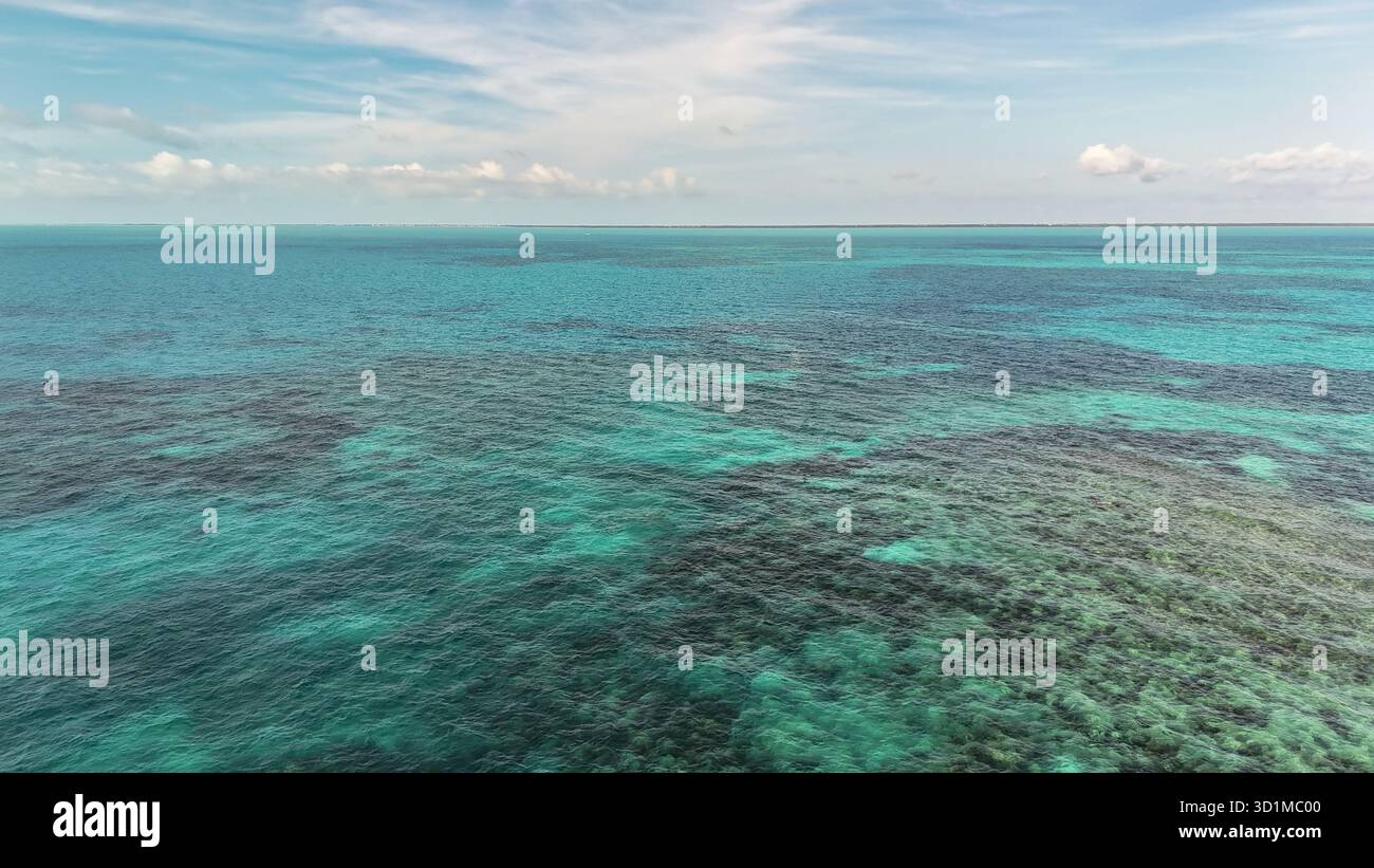 Vista aerea delle acque turchesi baciate dal sole brillano e danzano, rivelando le profondità nascoste e gli intricati motivi sotto la superficie, Key West, Florida Foto Stock