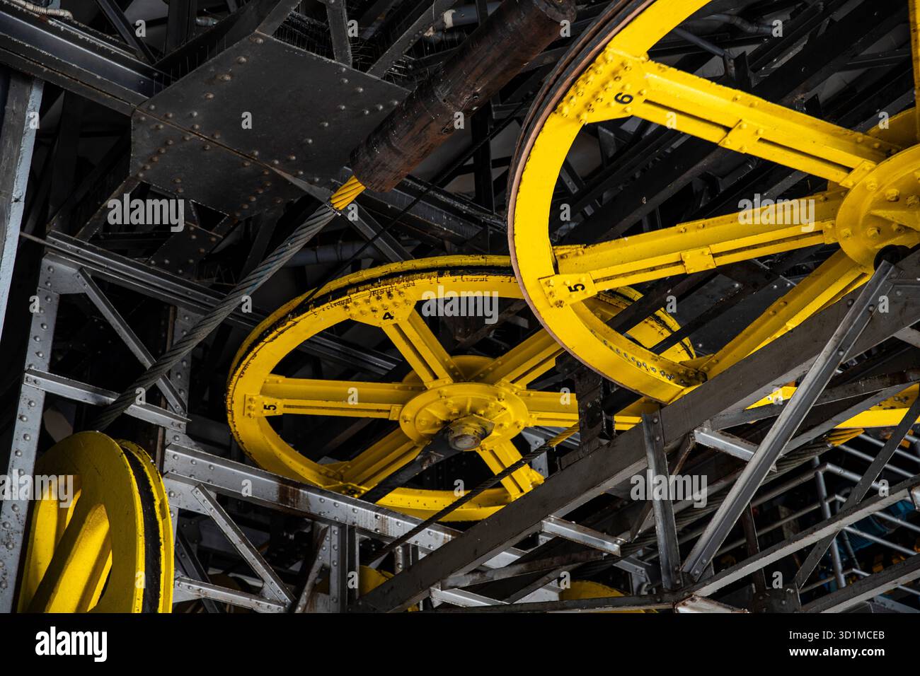 Tecnologia di sollevamento: Vecchie strutture metalliche e ruote motrici gialle, meccanismo Foto Stock