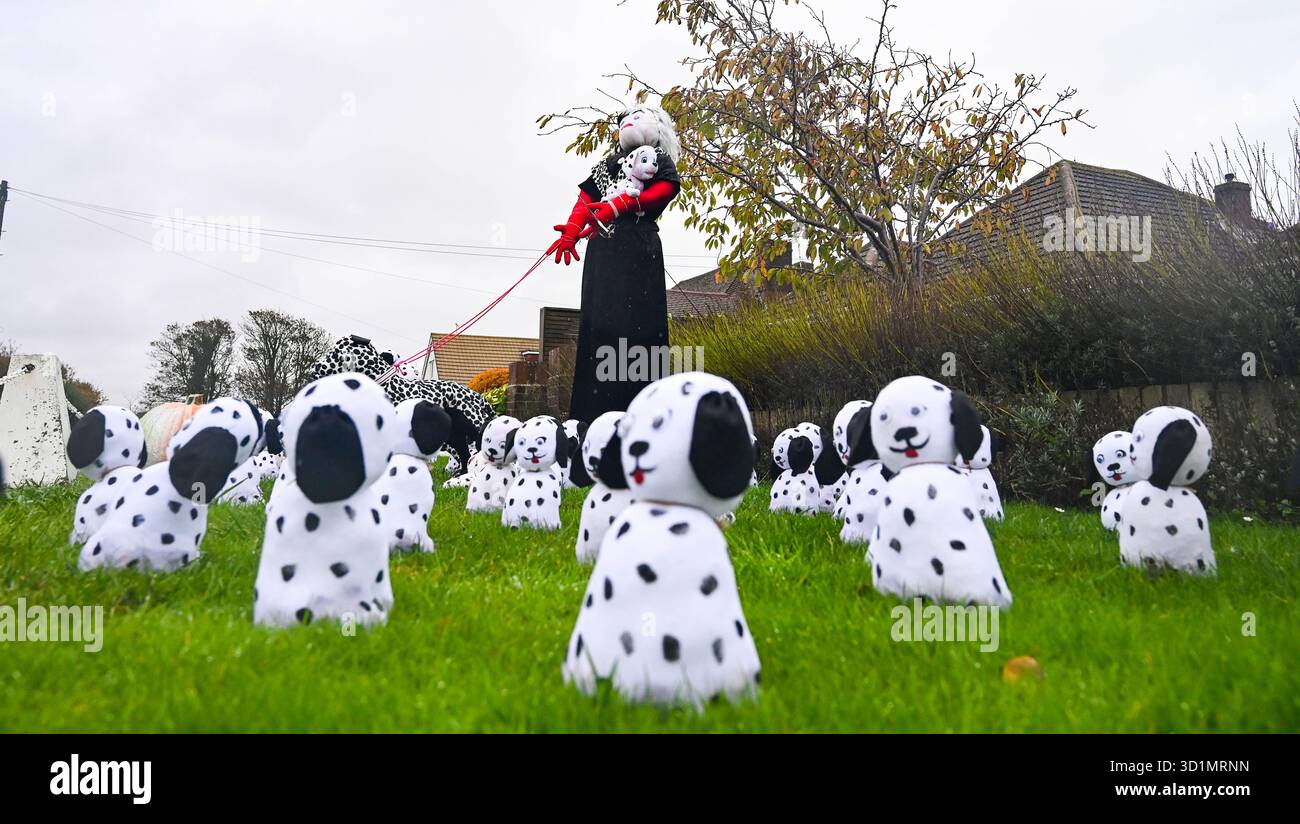 Worthing UK 29 ottobre 2025 - Cruella Deville e Dalmati partecipano a questo festival dello spaventapasseri del villaggio di Ferring vicino Worthng nel West Sussex . Oltre 50 spaventapasseri sono stati eretti intorno al villaggio per contribuire a sostenere quest'anno beneficenza che è la campagna Men in Sheds per la salute mentale: Credit Simon Dack /Alamy Live News Foto Stock