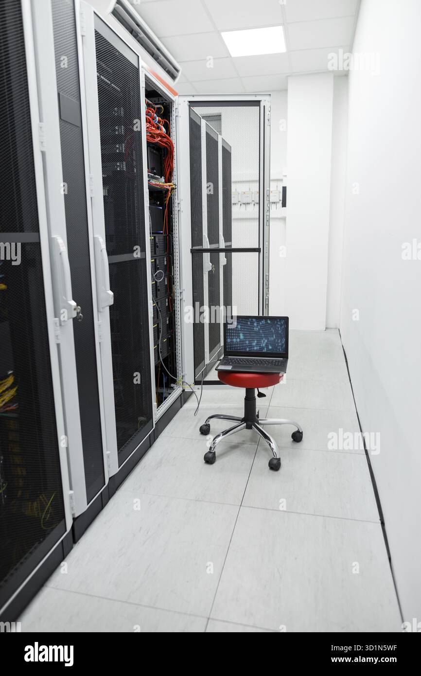 Bianco sala server con il computer portatile e i numeri sullo schermo, portatile per effettuare calcoli in datacenter Foto Stock