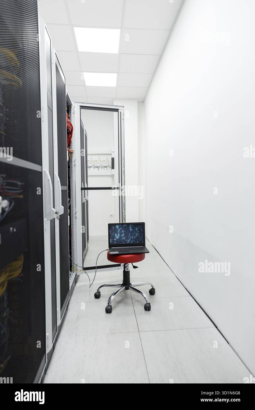 Bianco sala server con il computer portatile e i numeri sullo schermo, portatile per effettuare calcoli in datacenter Foto Stock