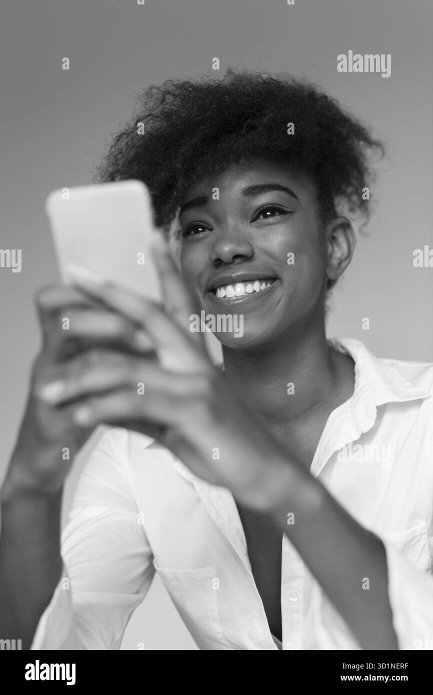 Casual imprenditrice texting sul telefono nel suo ufficio Foto Stock