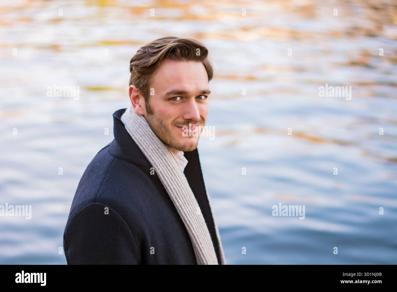 Giovane uomo all'aperto d'inverno in riva al lago o al fiume Foto Stock