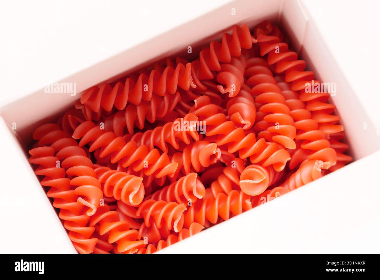 Pasta fusilli di lenticchie rosse crude in scatola di carta bianca Foto Stock