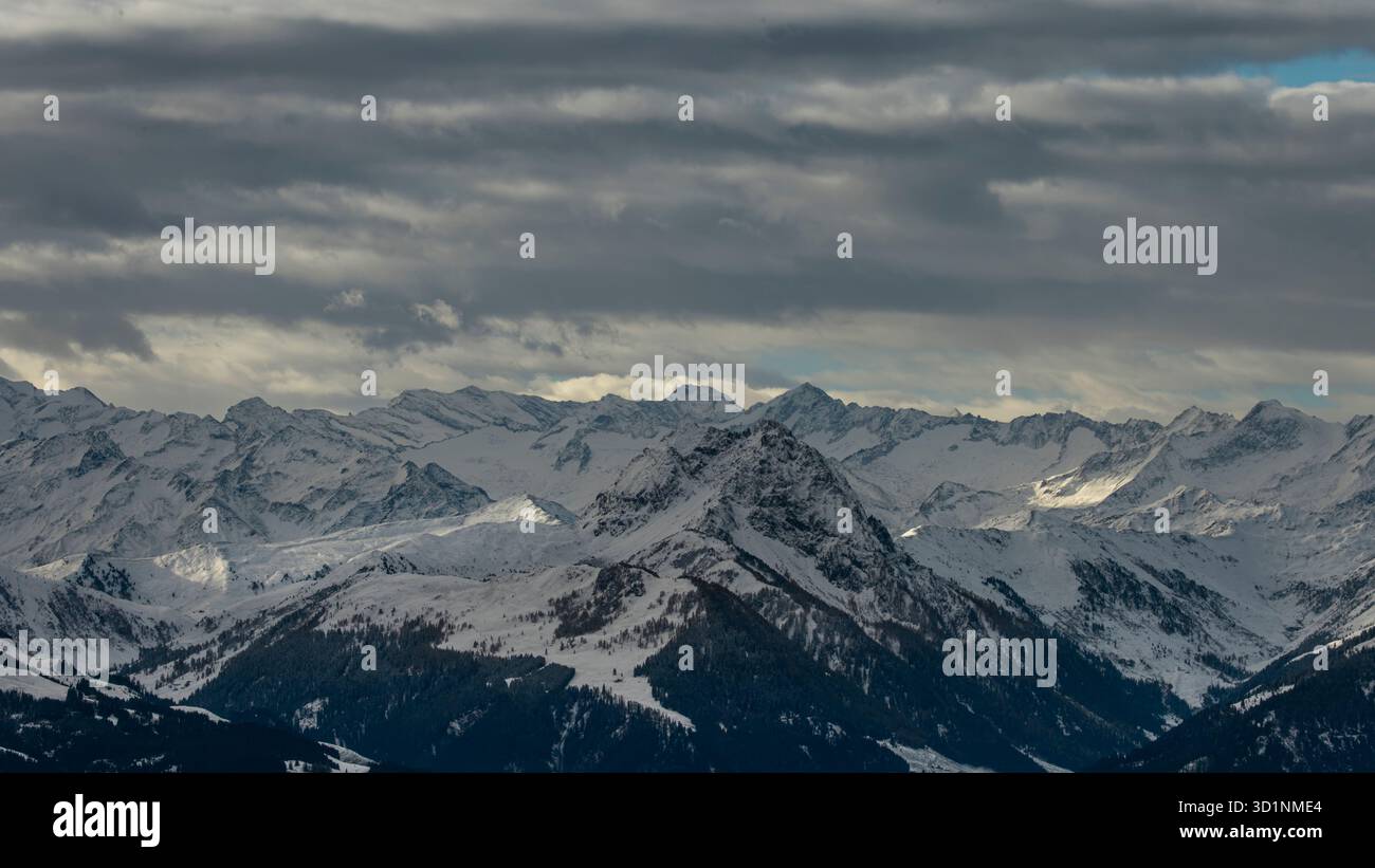 Il Corno di Kitzbüheler in Tirolo, Austria, dopo la prima nevicata della stagione. Le spettacolari nuvole invernali si estendono lungo la cresta alpina, rivelando un'atmosfera frizzante Foto Stock