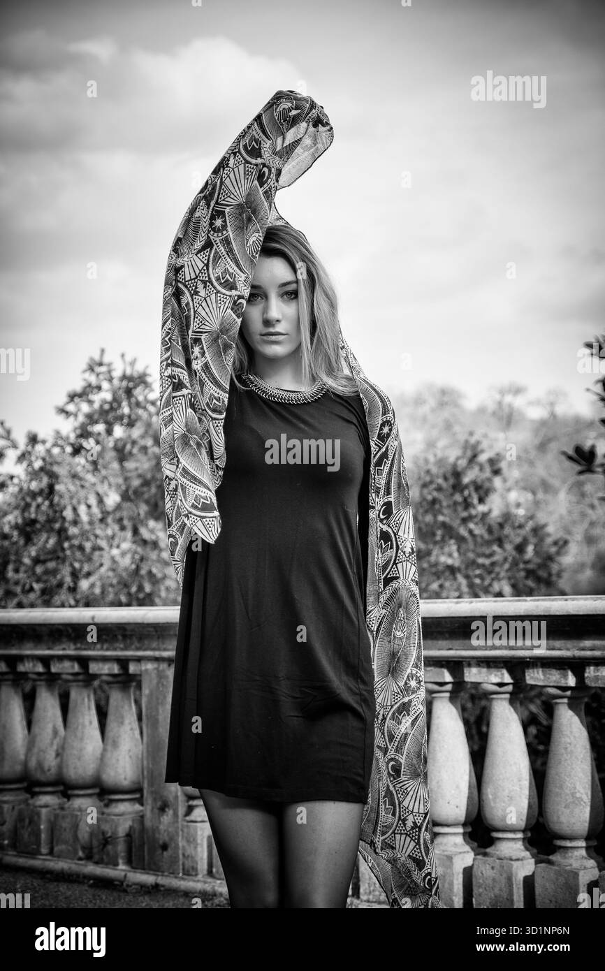 Bella giovane donna in abito nero per esterno Foto Stock