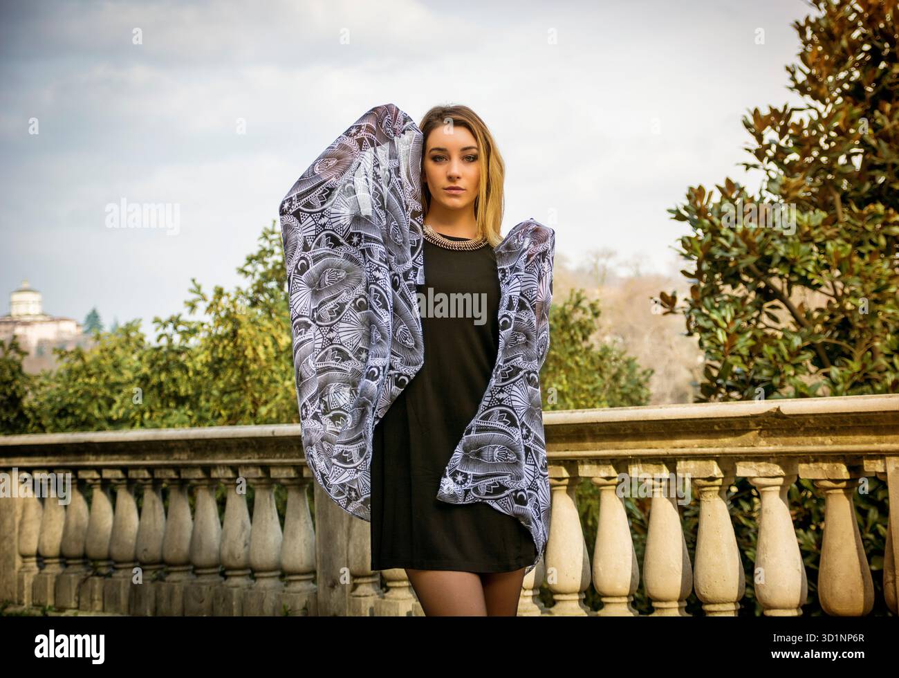 Bella giovane donna in abito nero per esterno Foto Stock