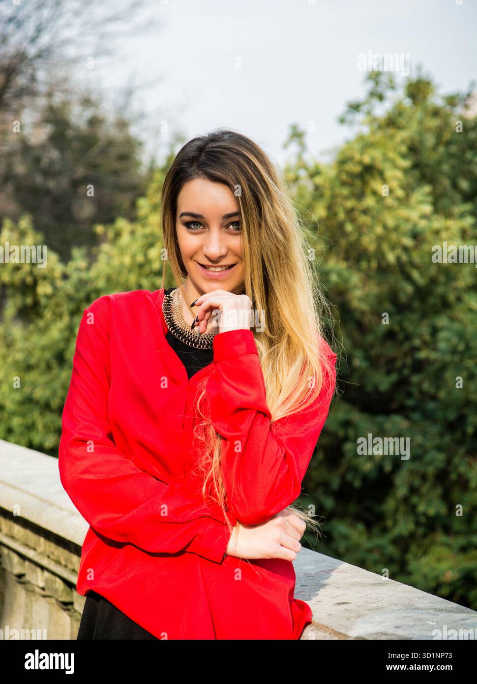 Bella giovane donna in abito rosso, all'aperto Foto Stock