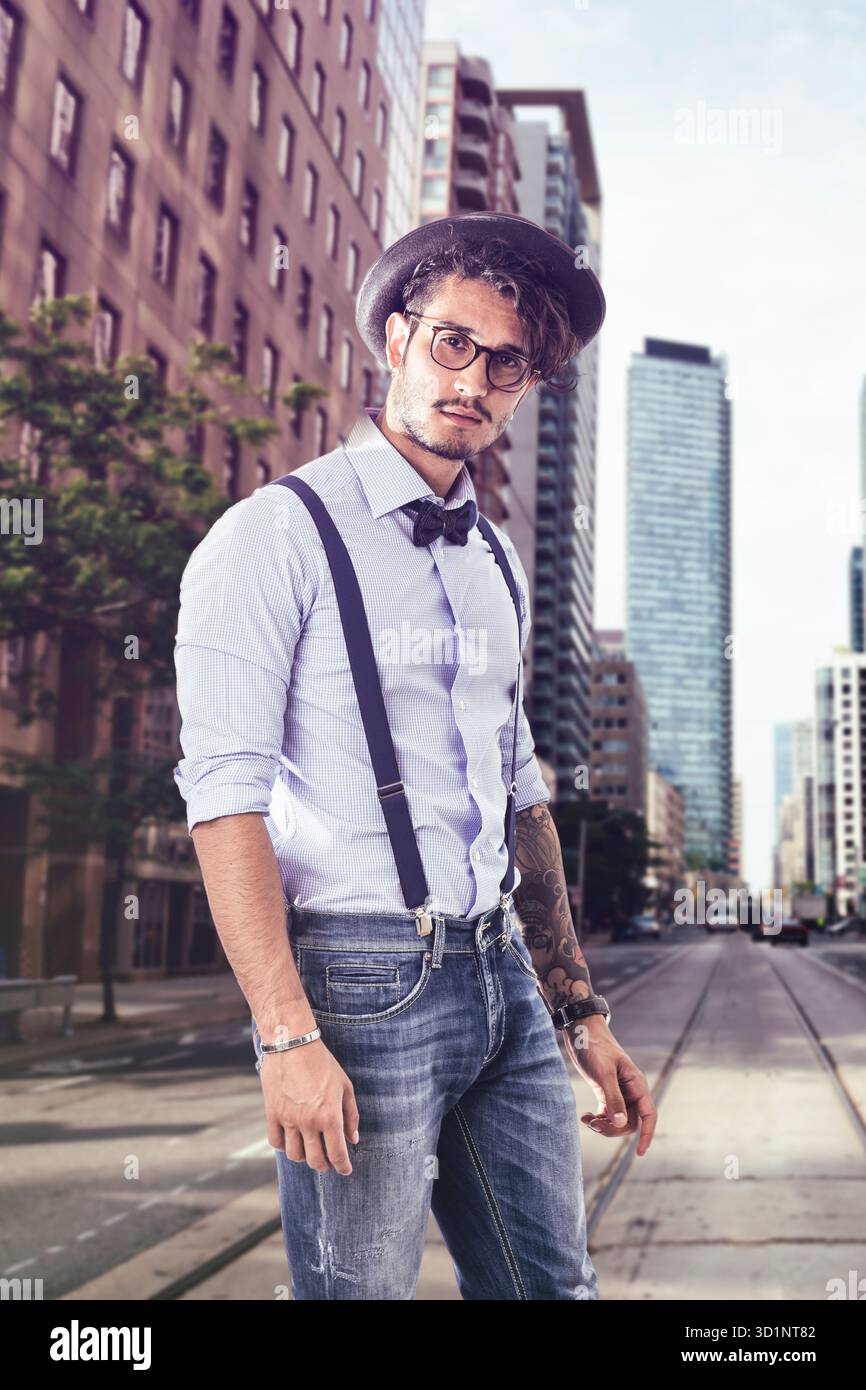 Giovane uomo in cappello, occhiali, bow tie-in e giarrettiere guardando la fotocamera Foto Stock