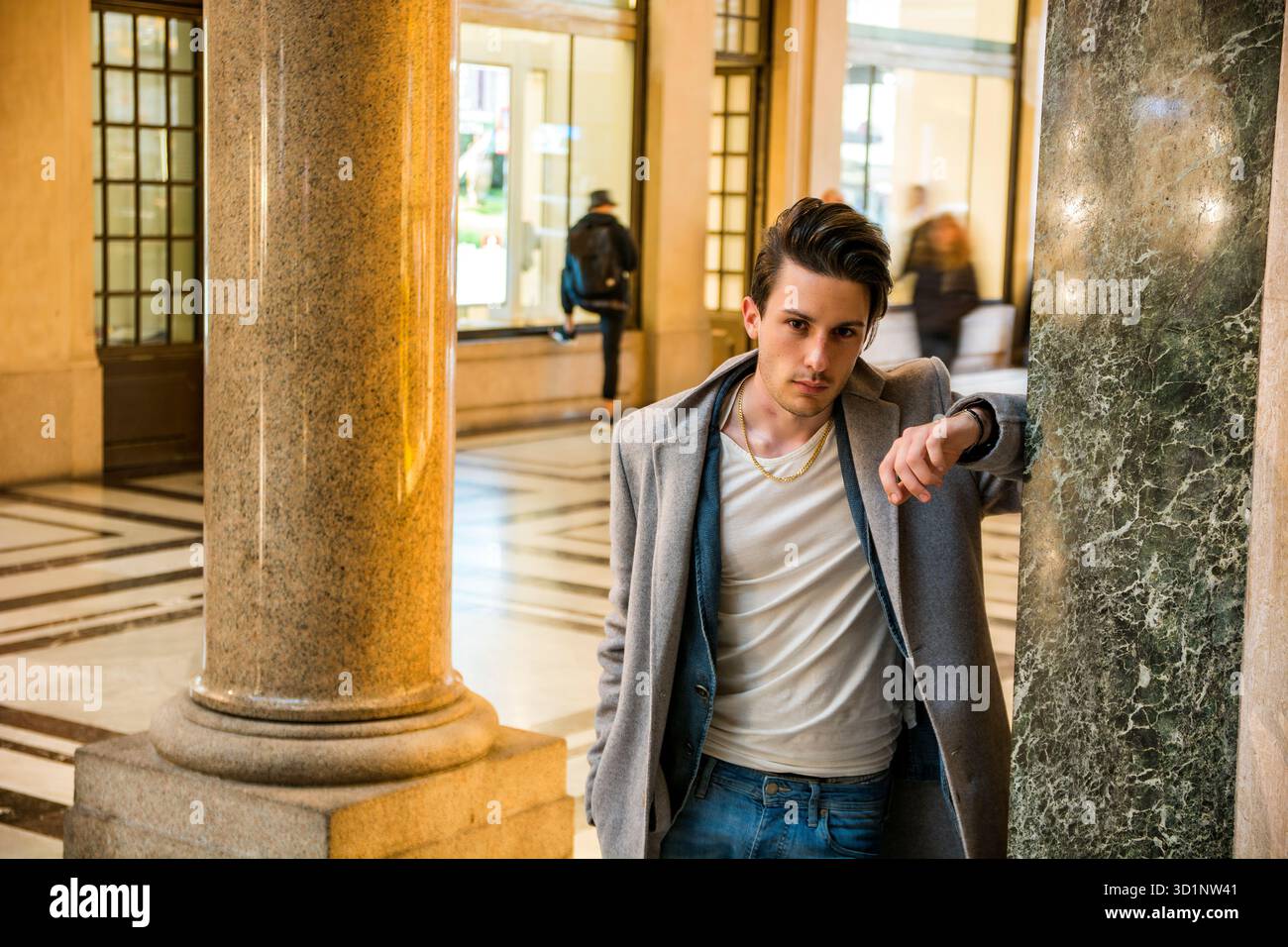 Ritratto di un bel giovane appoggiato su una colonna di marmo Foto Stock