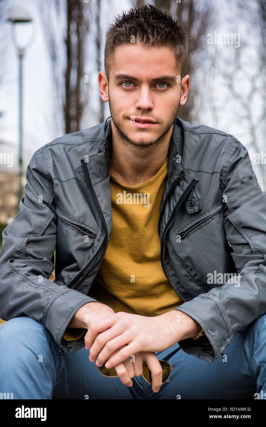 Bel giovane guardando la fotocamera in posizione di parcheggio Foto Stock