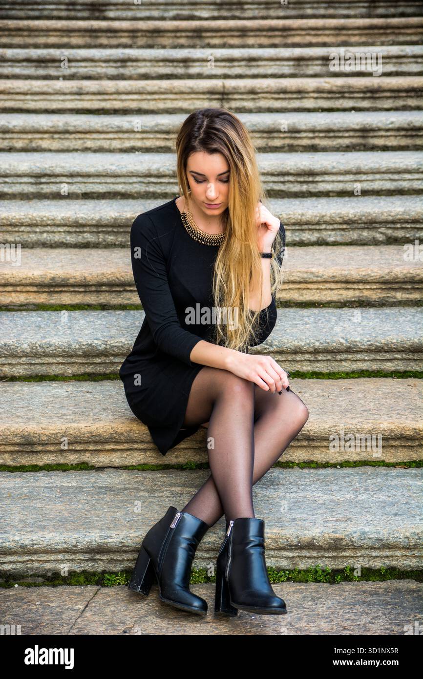 Bella giovane donna in abito nero per esterno Foto Stock