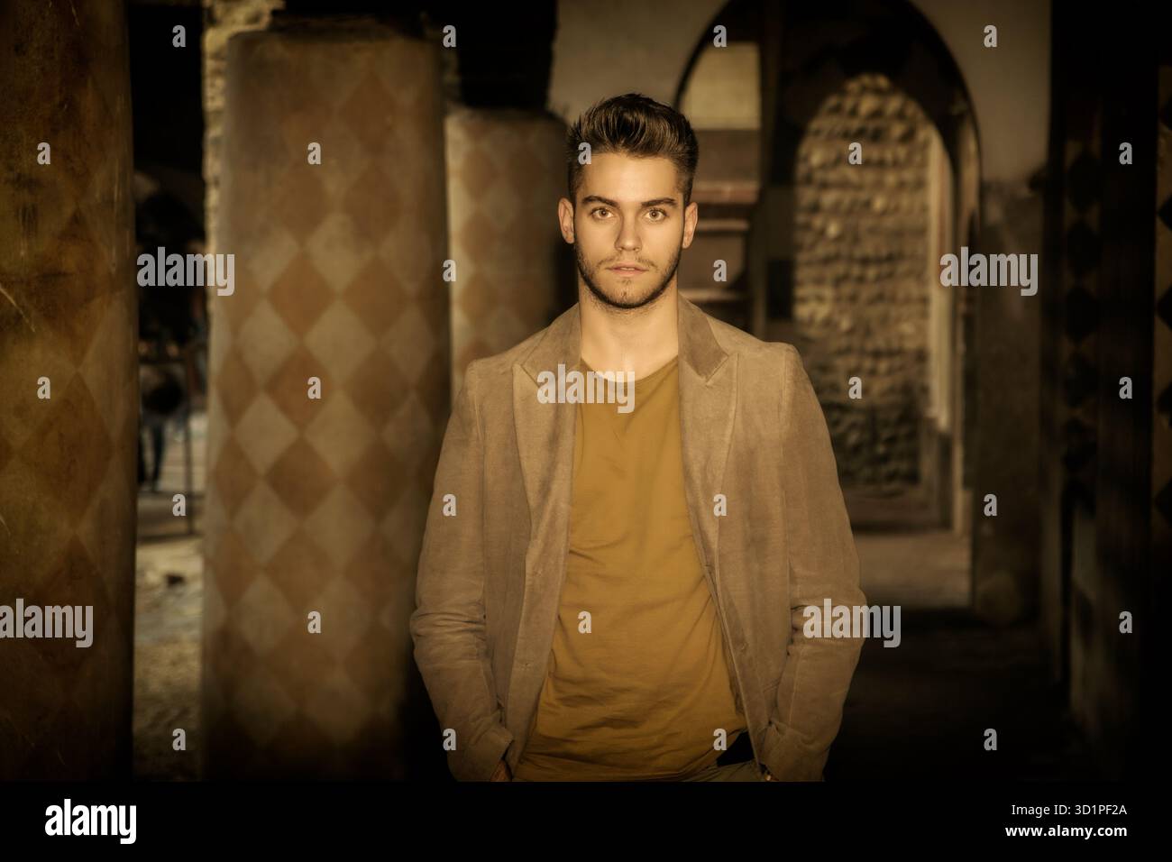 Un giovane attraente in piedi contro il vecchio muro Foto Stock