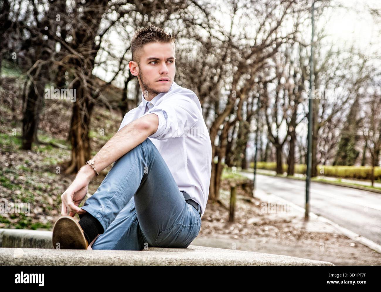 Bel giovane guardando la fotocamera in posizione di parcheggio Foto Stock