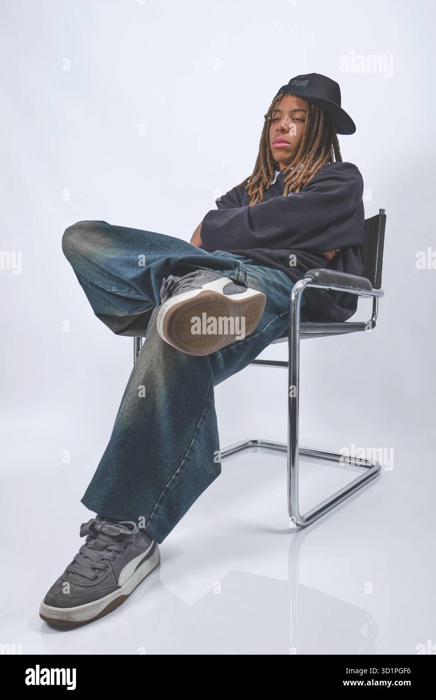 Giovane uomo con dreadlock che rilassa lo streetwear urbano. Foto Stock