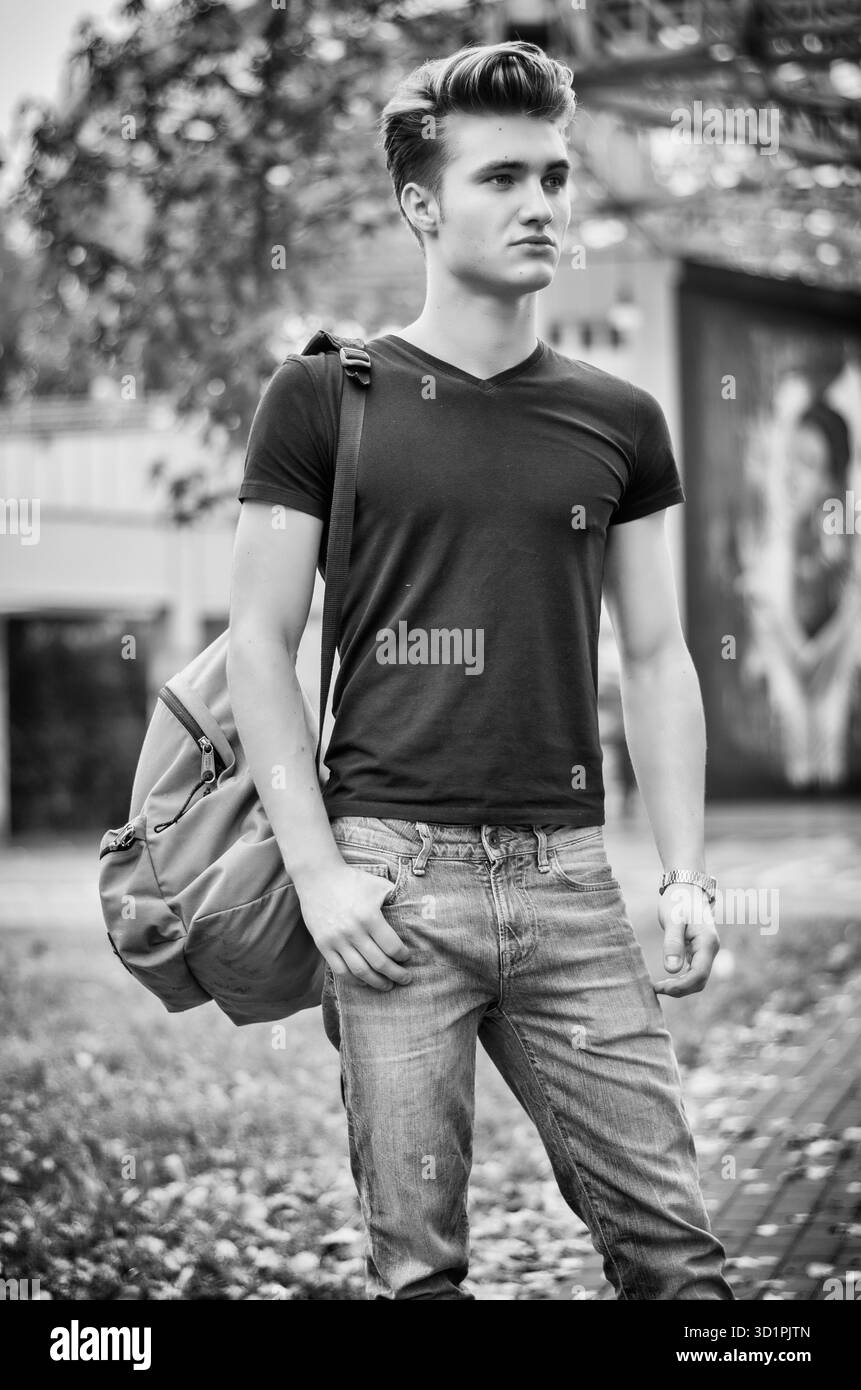 Giovane uomo in piedi in ambiente cittadino, con backsack Foto Stock
