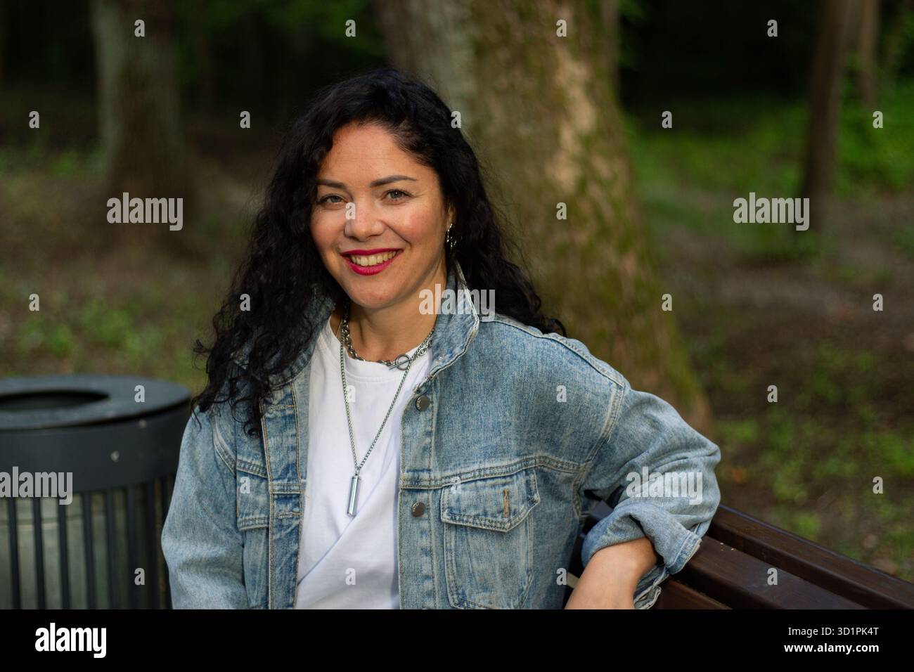 Donna che si gode momenti tranquilli nel parco pubblico. Donna pensiva. Un momento sincero. Sentimenti di tranquillità consapevolezza e connessione con la natura. Foto Stock