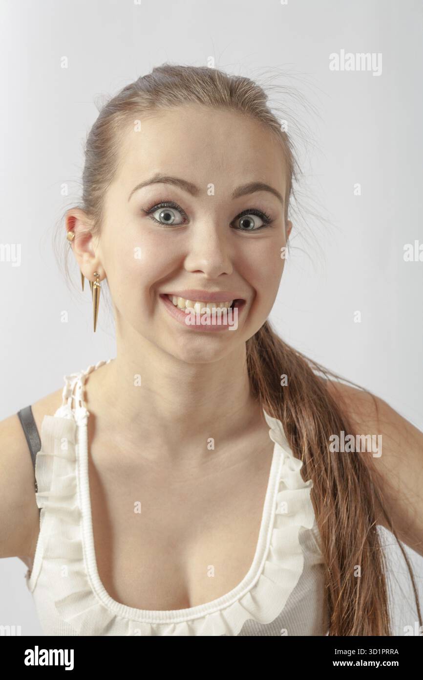Giovane donna di 20-24 anni che guarda la macchina fotografica sul bianco. Divertimento e gioia con sorriso Foto Stock