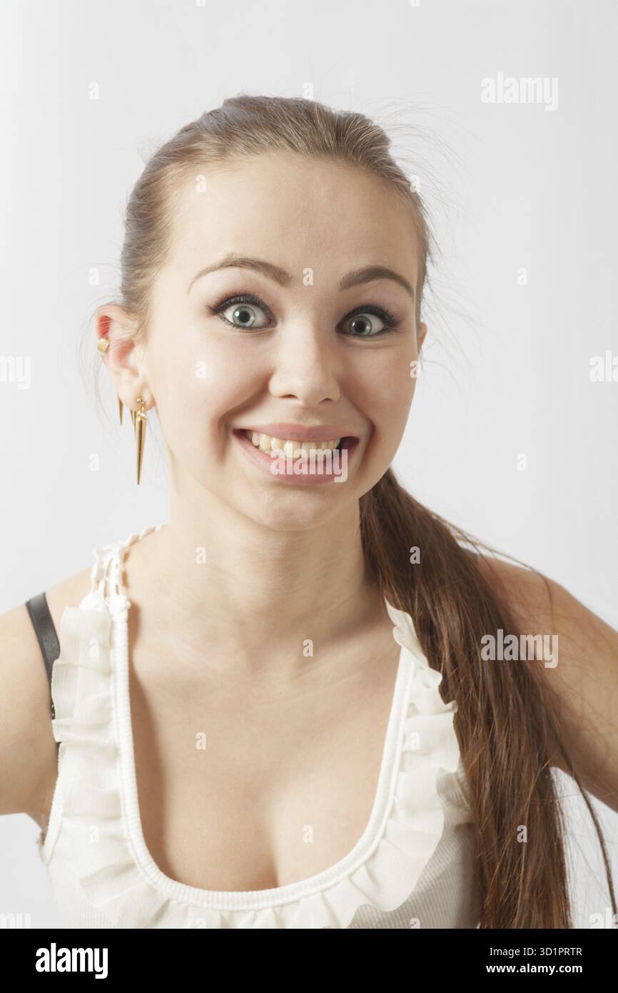 Giovane donna di 20-24 anni che guarda la macchina fotografica sul bianco. Divertimento e gioia con un sorriso di spugna sullo sfondo bianco Foto Stock