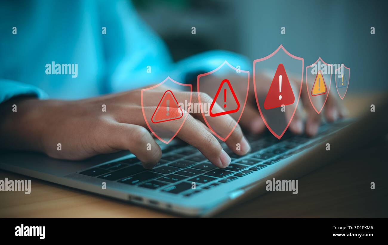 Digitazione manuale sul notebook con icone di avviso di sicurezza informatica. Concetto di protezione dei dati online, avviso di sicurezza del sistema e prevenzione dei rischi su Internet. Foto Stock
