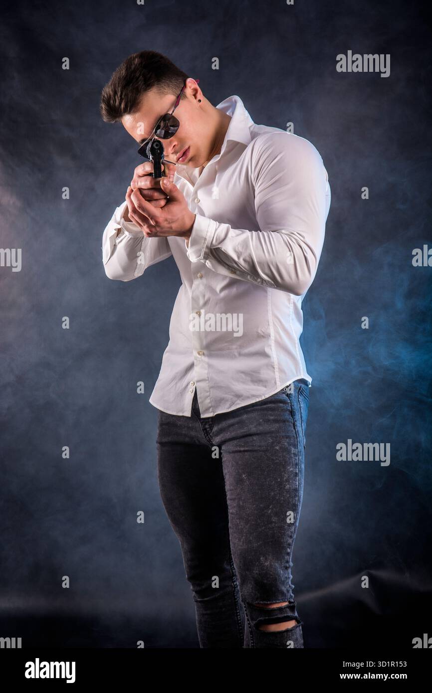 Giovane uomo pistola di puntamento Foto Stock