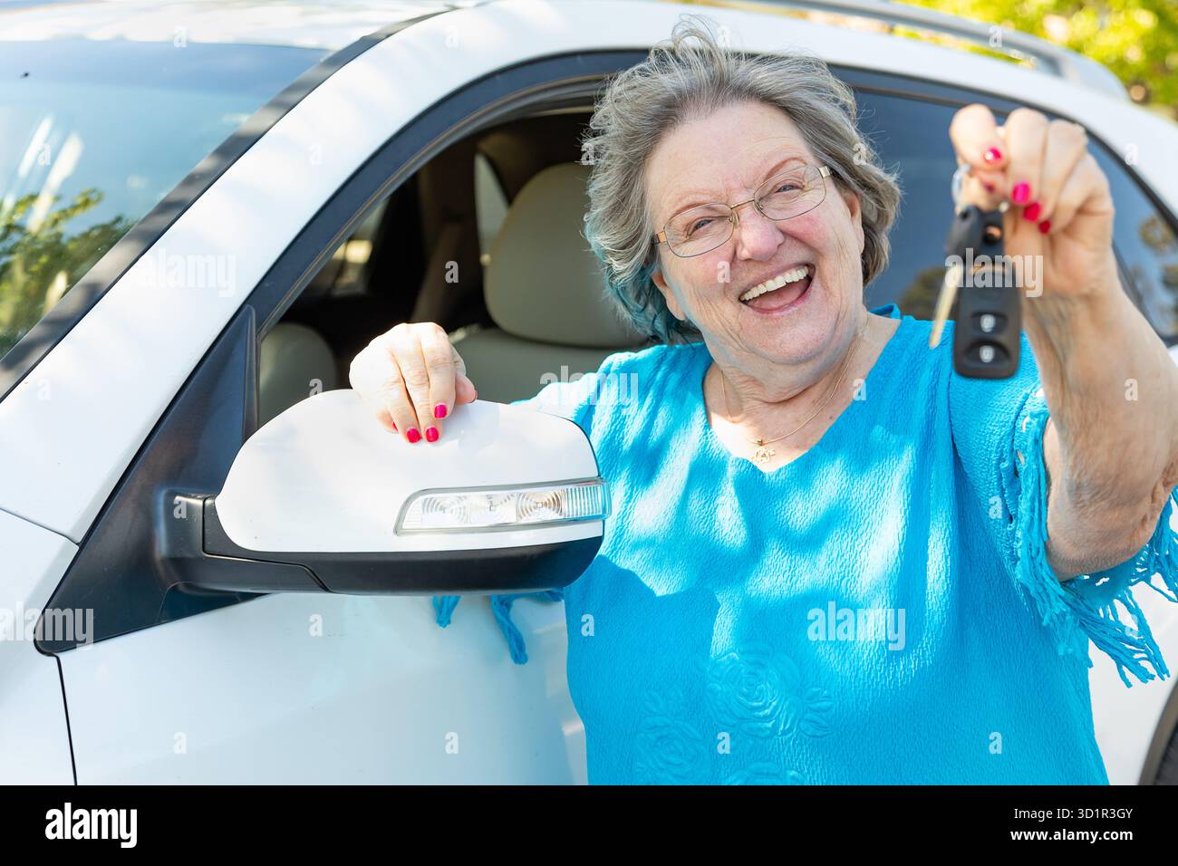 Donna anziana felice con nuova auto e chiavi Foto Stock