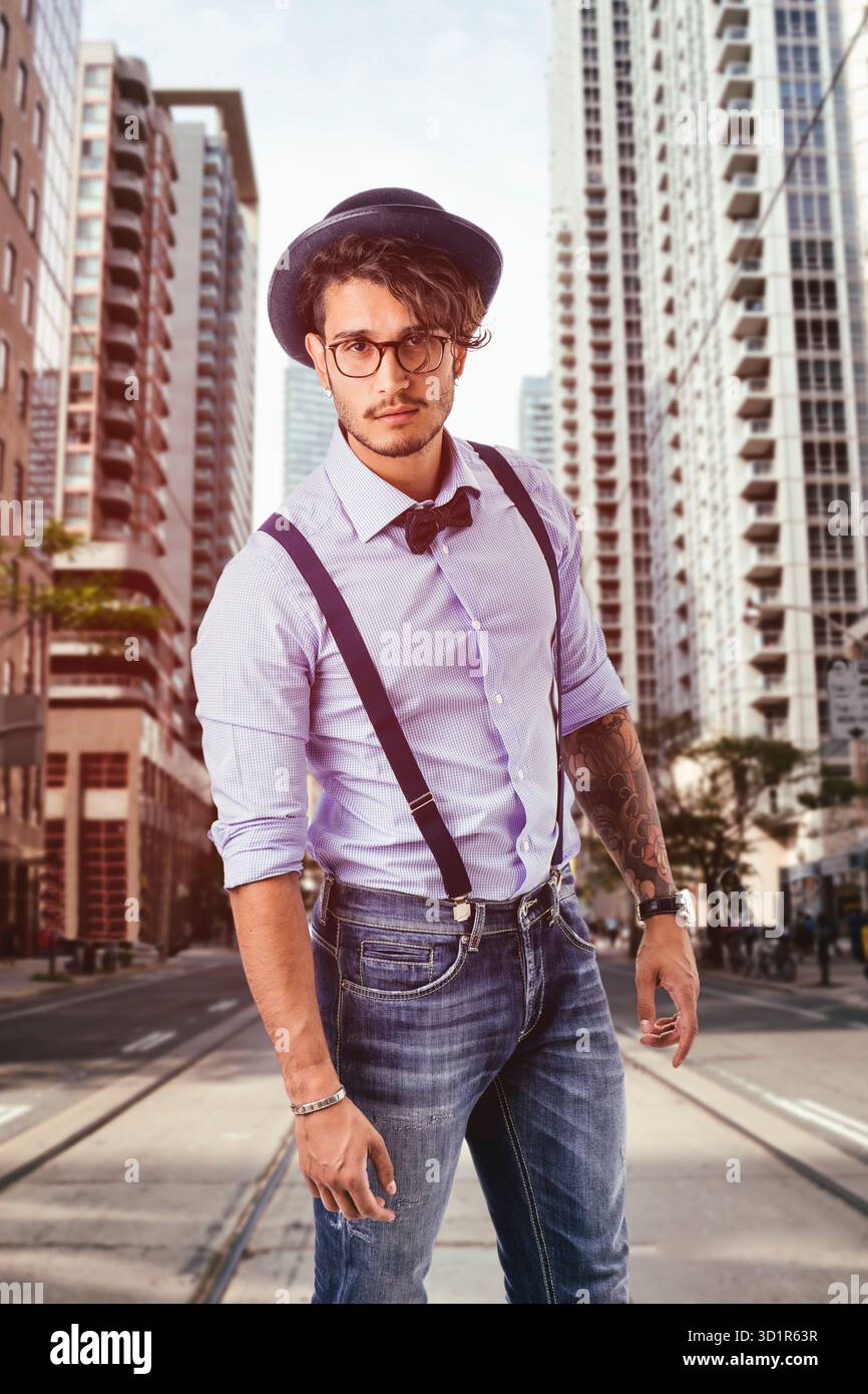 Giovane uomo in cappello, occhiali, bow tie-in e giarrettiere guardando la fotocamera Foto Stock