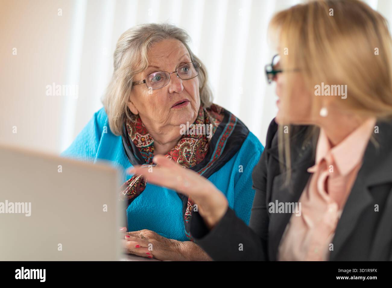 Donna che aiuta Senior Adult Lady su un computer portatile Foto Stock