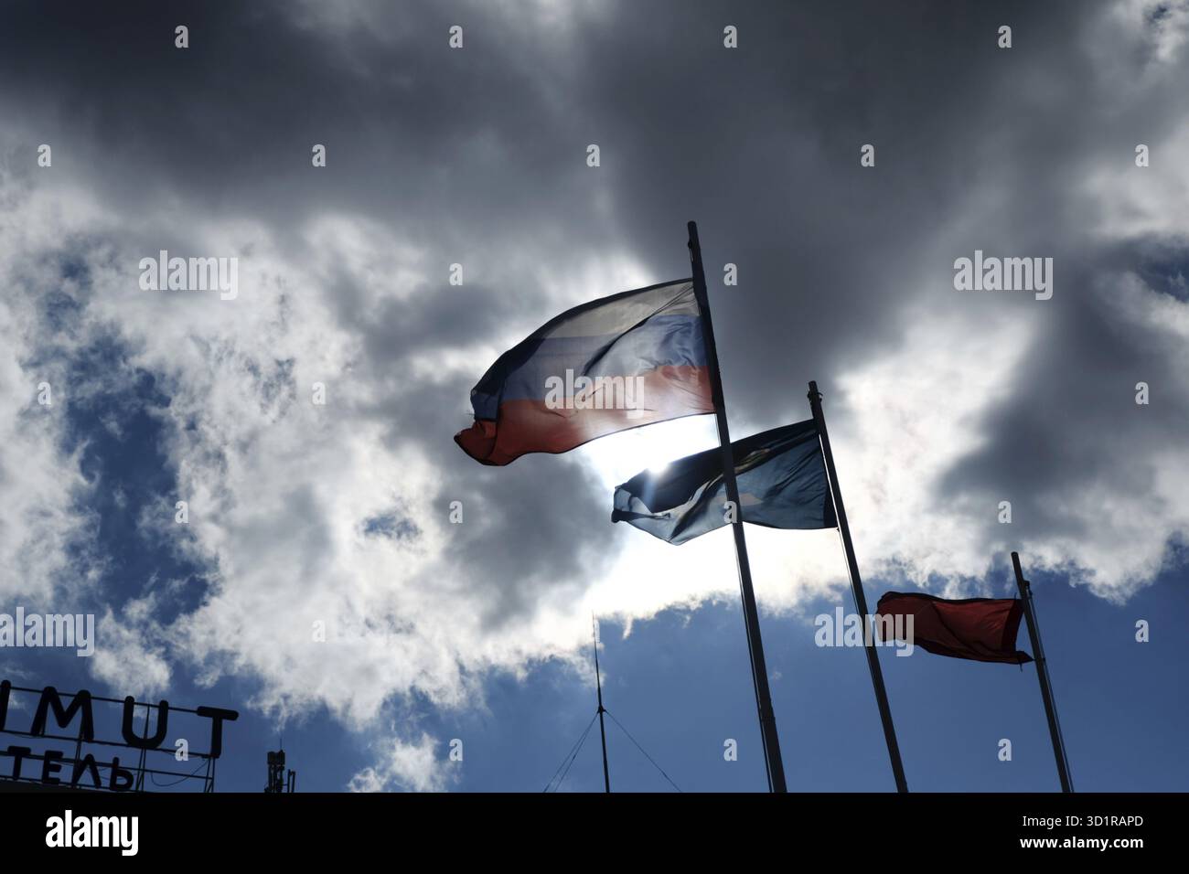 Bandiera russa sul vento contro damatic nuvole e la bandiera della regione di Astrakhan accanto Foto Stock