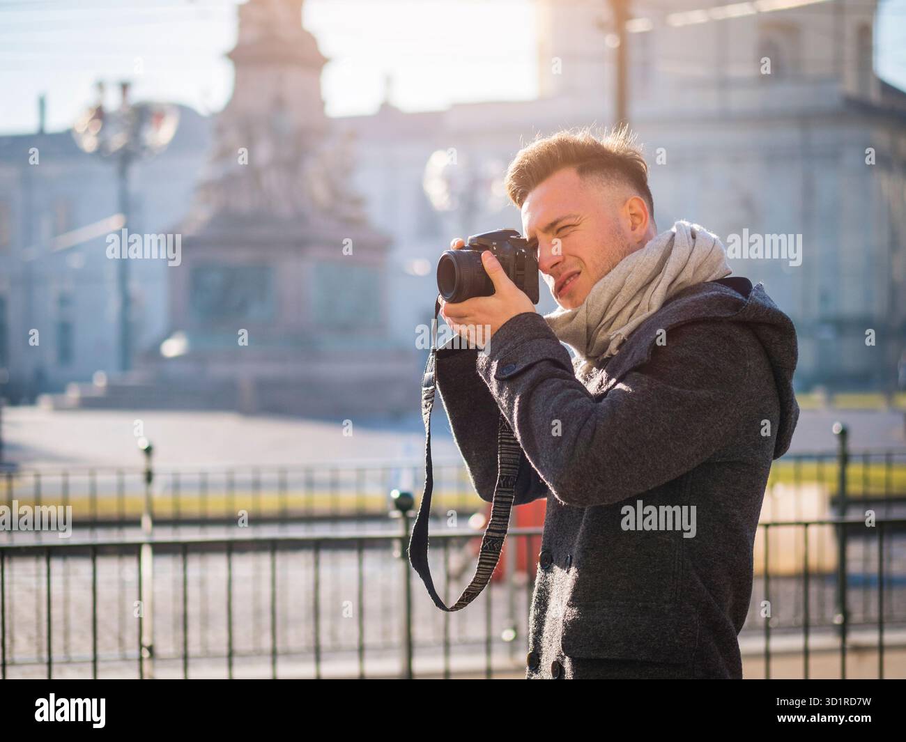 Bel giovane fotografo maschio tenendo fotografia all'aperto Foto Stock
