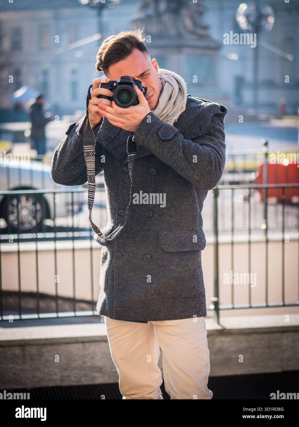 Bel giovane fotografo maschio tenendo fotografia all'aperto Foto Stock