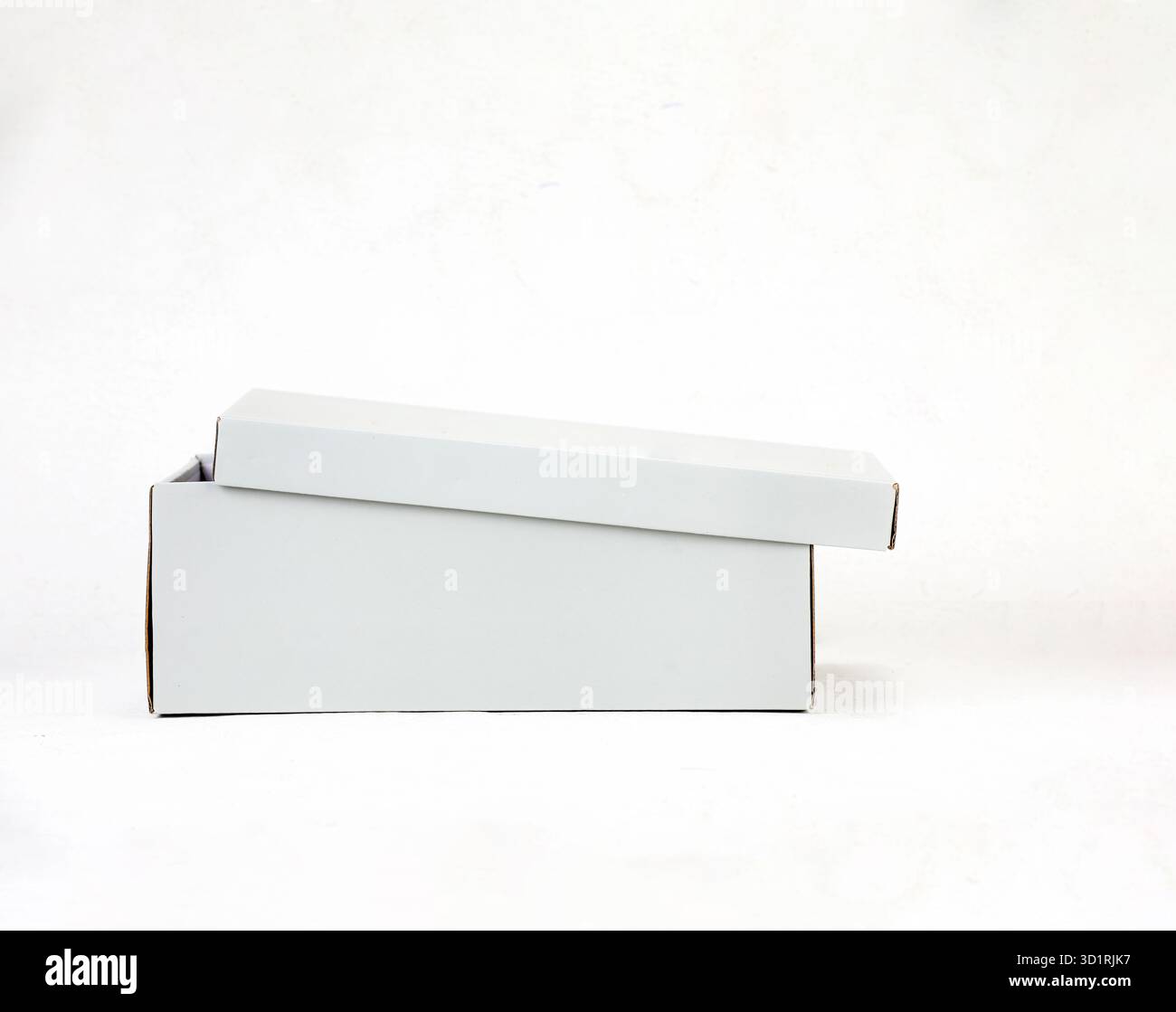 Confezione regalo bianca aperta dal design minimalista con carta velina su sfondo pulito Foto Stock