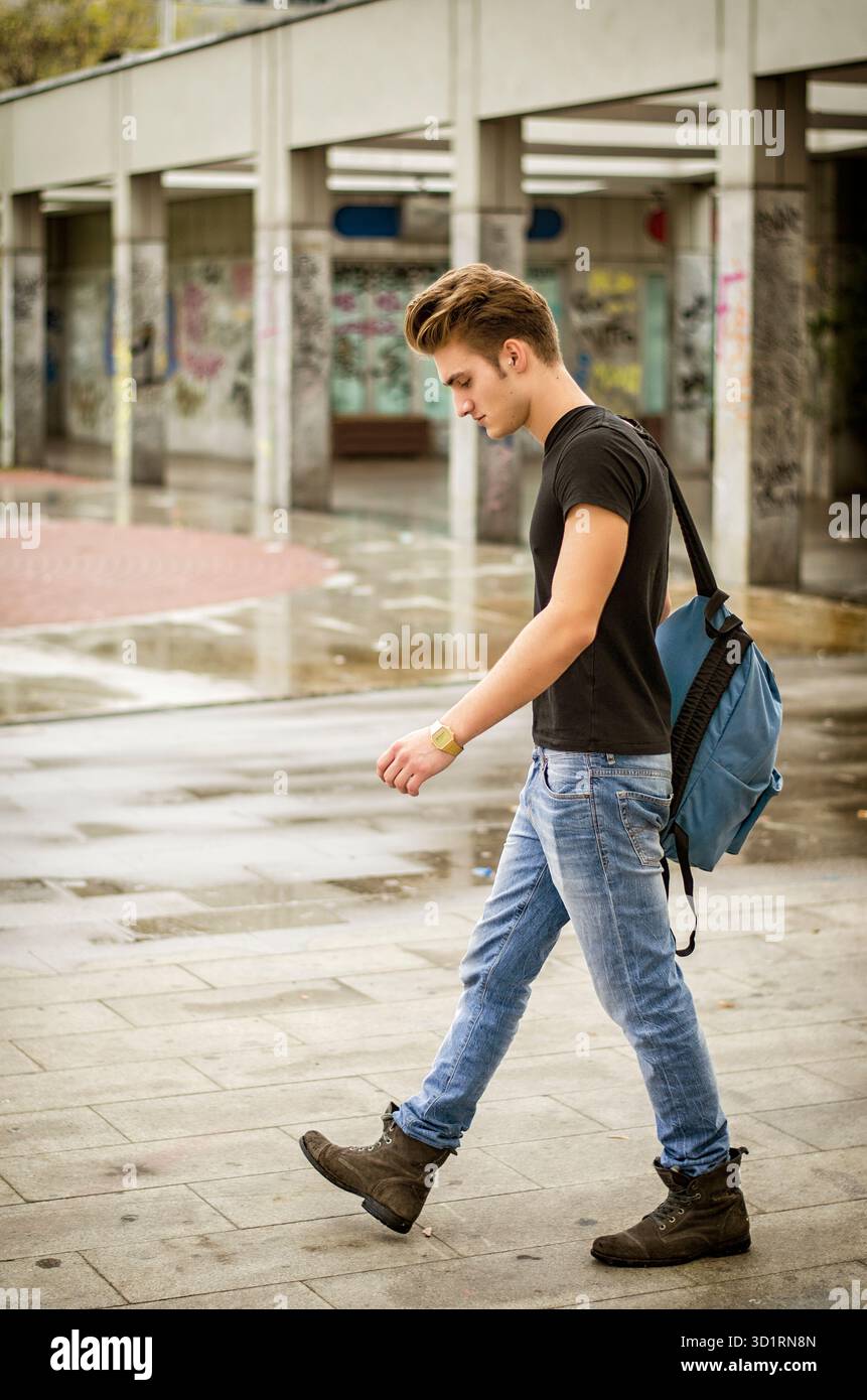 Giovane attraente con zaino che cammina all'aperto Foto Stock