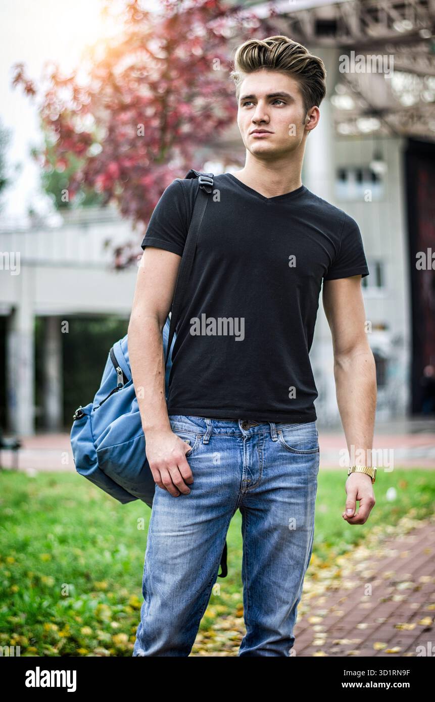 Giovane attraente con zaino in piedi all'aperto Foto Stock