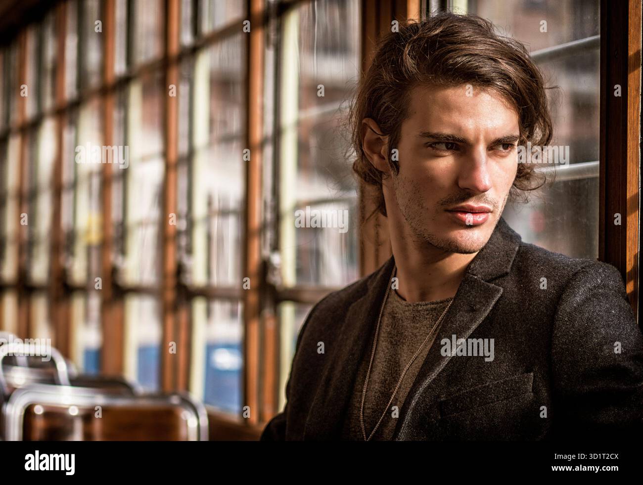 Giovane uomo a cavallo su tram o bus vecchio in città Foto Stock