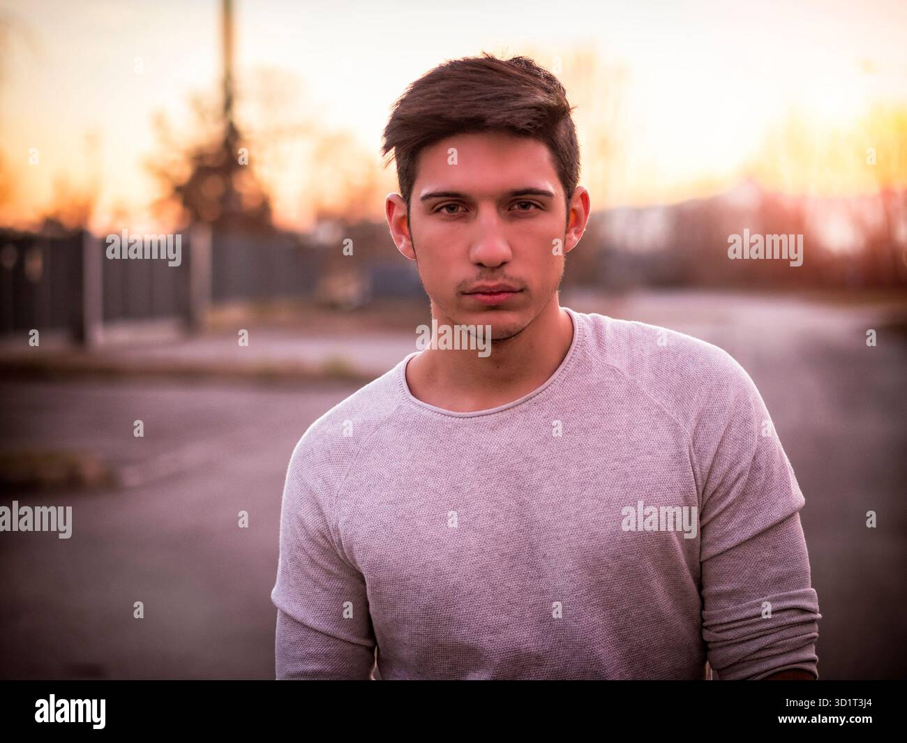 Bel giovane uomo in maglia bianca all'aperto in strada Foto Stock