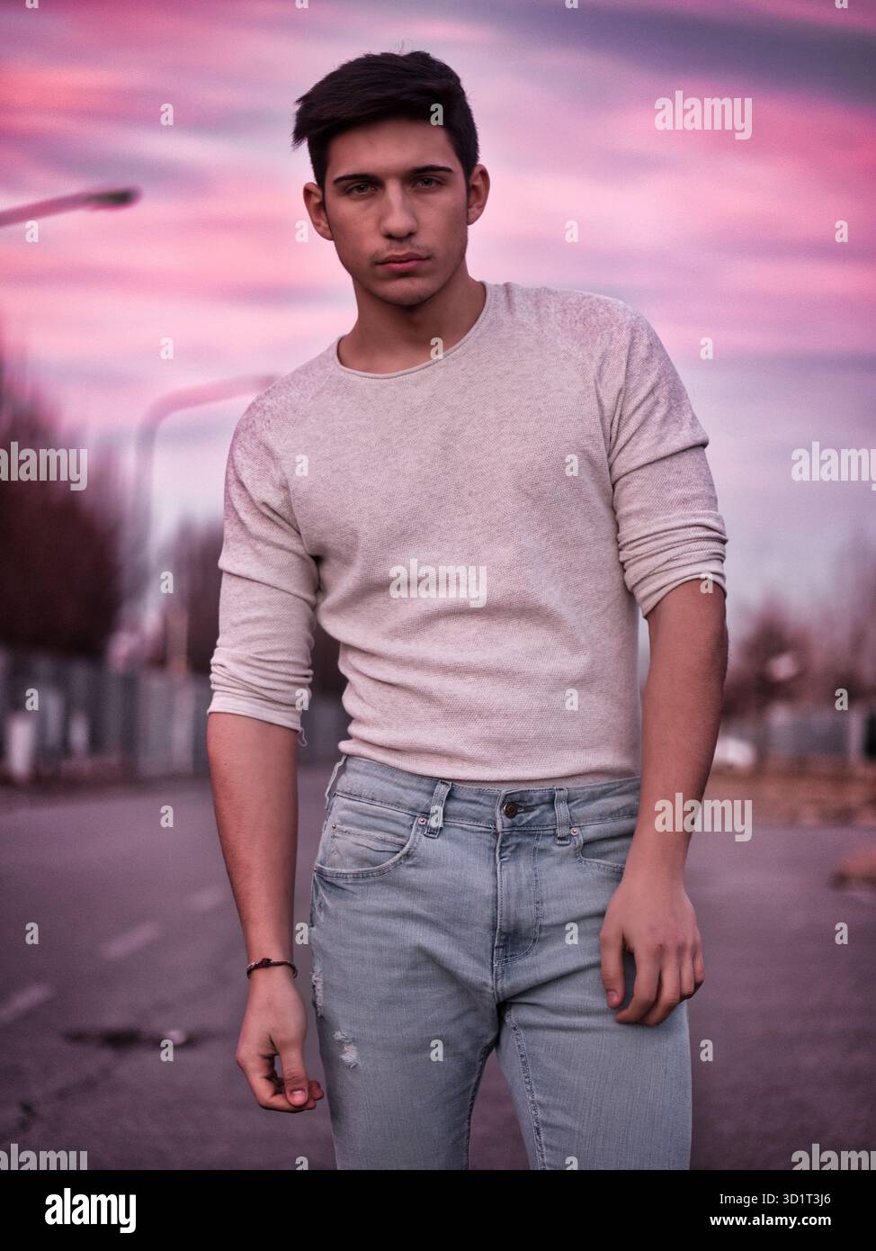 Bel giovane uomo in maglia bianca all'aperto in strada Foto Stock